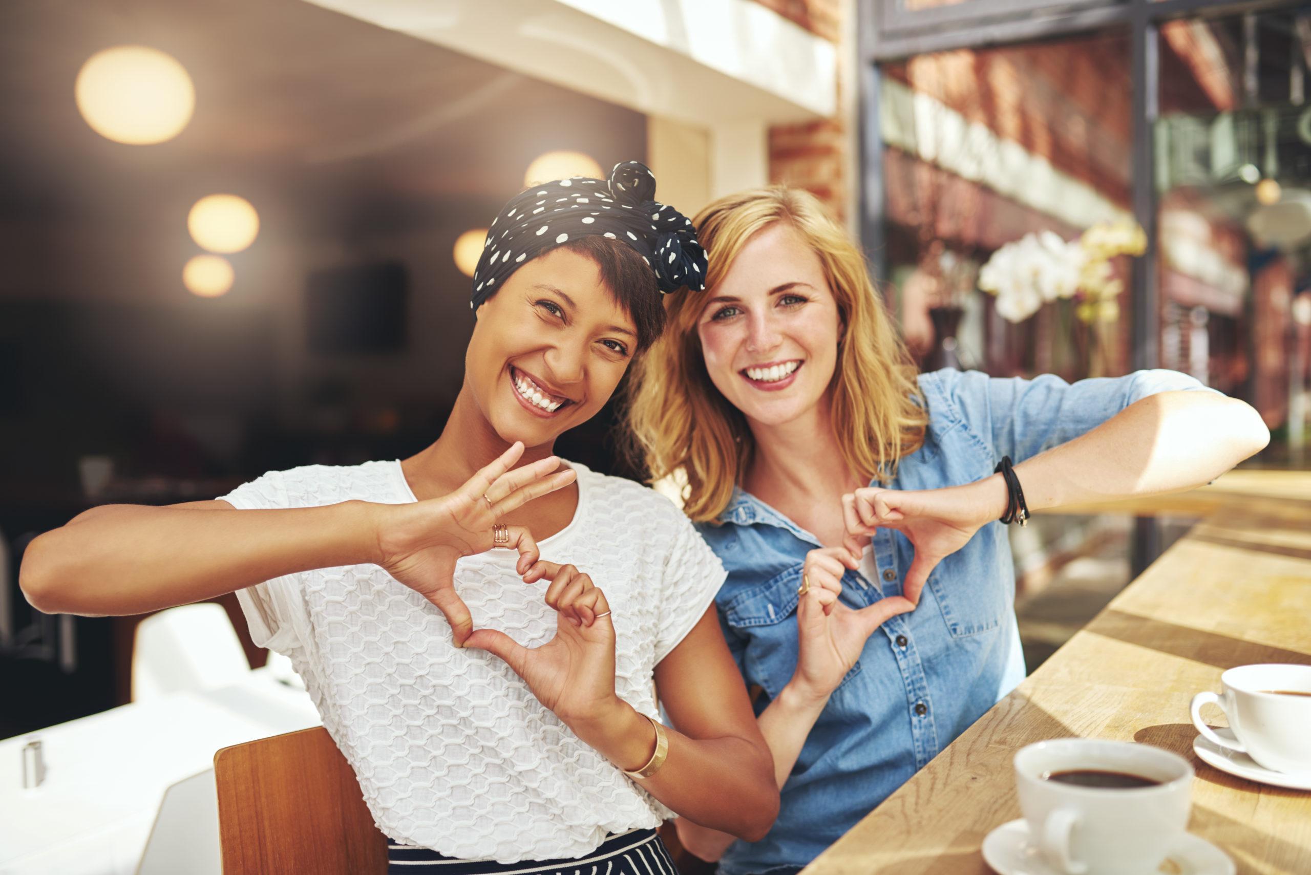 2 ladies making heart shape with hand