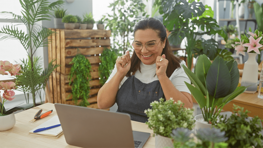 Gardener business owner celebrating on laptop